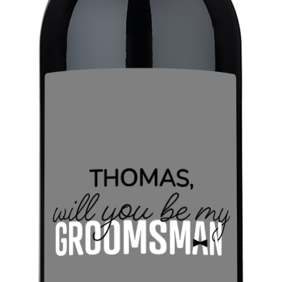 Custom “Will You Be My Groomsman?” wine bottle for Thomas, Houston TX 12.01.24, on a plain gray background.