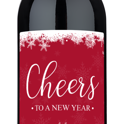 A wine bottle with a red label decorated with white snowflakes and Cheers to a New Year text.