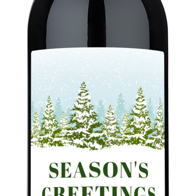 A wine bottle with a Seasons Greetings label featuring snowy trees and festive holiday decor.