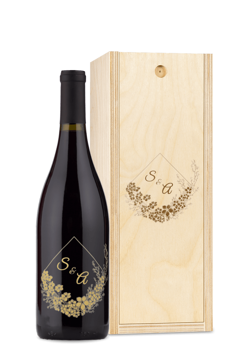 A wood wine box engraved with gold floral patterns and the initials S & A.